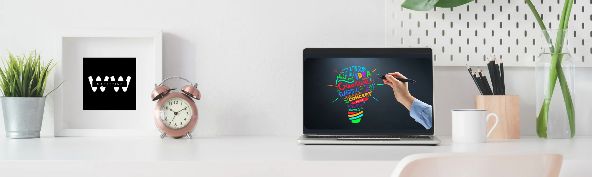 clean desktop with logo, clock, open laptop, and plant
